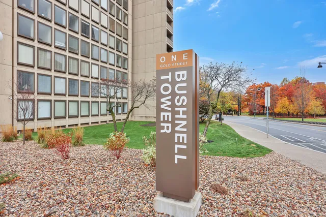 a view of a building with a yard and trees