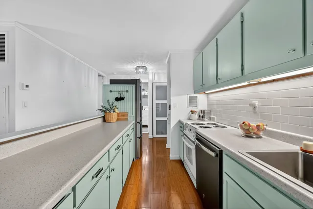 a kitchen with stainless steel appliances a sink stove and cabinets
