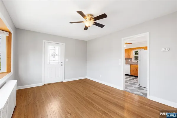 a view of a livingroom with a ceiling fan and wooden floor