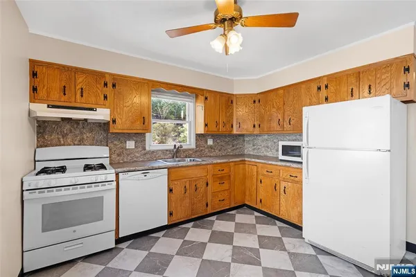 a kitchen with granite countertop appliances a sink and cabinets