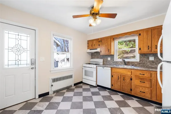 a kitchen with granite countertop stainless steel appliances a stove a sink and a window