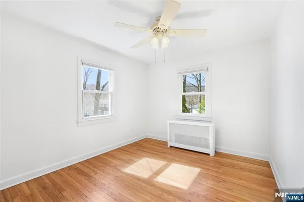 an empty room with windows and cabinet
