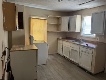 a kitchen with cabinets appliances and a window
