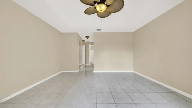 an empty room with chandelier fan