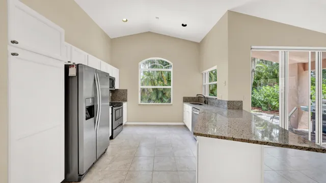 an empty room with windows and ceiling fan
