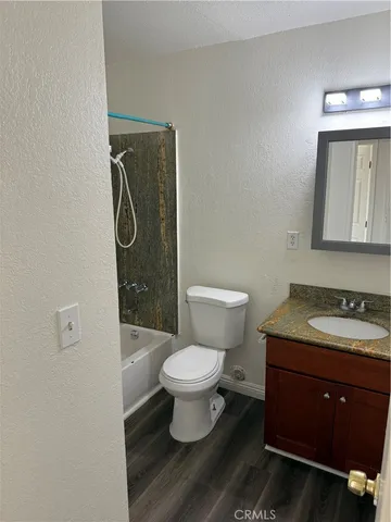 a bathroom with a toilet sink vanity and mirror