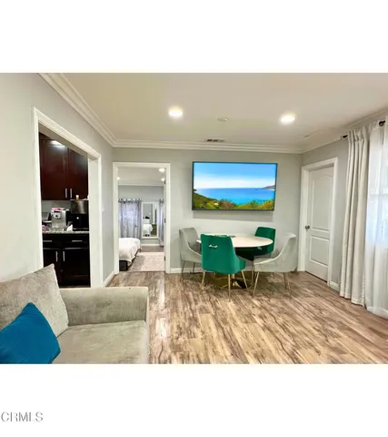 a living room with furniture a dining table and kitchen view