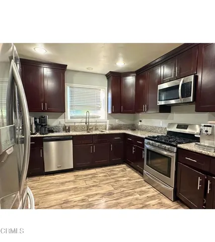 a kitchen with stainless steel appliances kitchen island granite countertop a stove a sink and a microwave