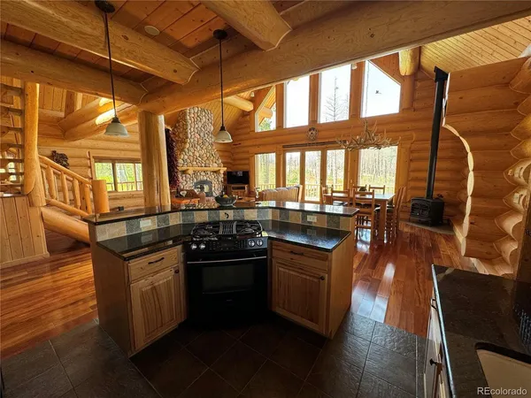 a kitchen with stainless steel appliances granite countertop a stove and a wooden floors
