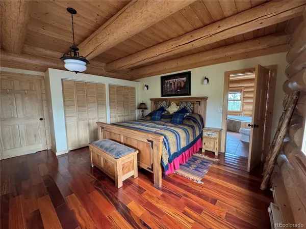 a bedroom with a bed wooden floor and window