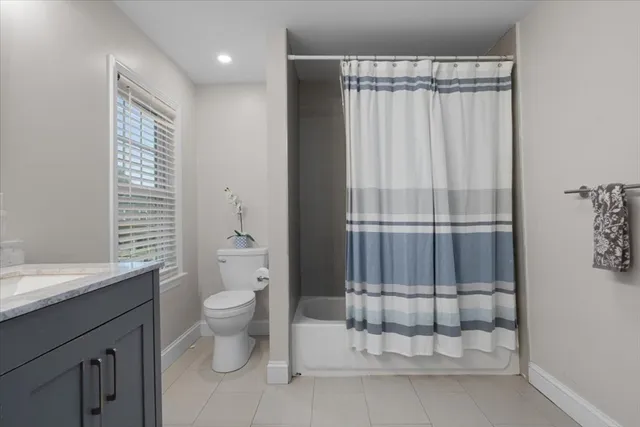 a bathroom with a granite countertop sink a toilet and shower