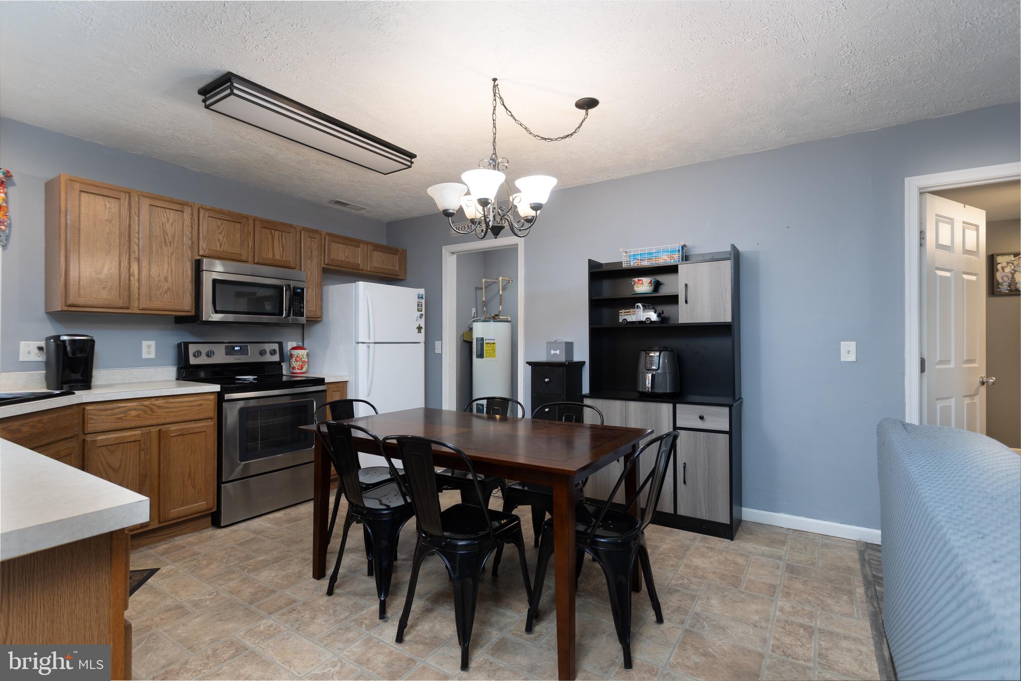 1303 Colonial Avenue Cambridge, MD 21613 - Photo 4 of 12 a kitchen with a table chairs refrigerator and microwave