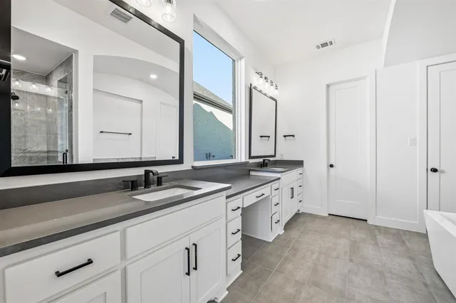 a large bathroom with a double vanity sink and mirror