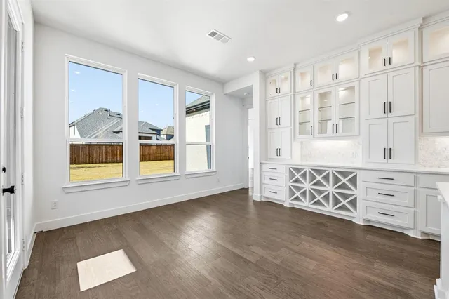 an entryway with wooden floor and cabinet