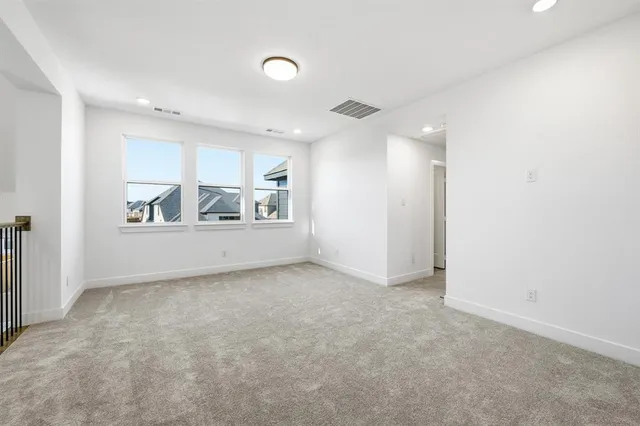 an empty room with windows and fireplace