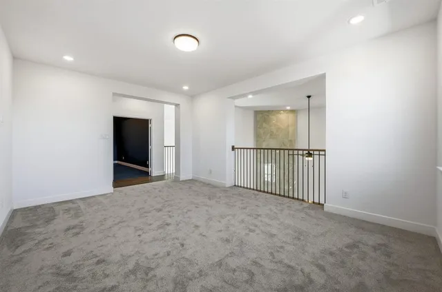 an empty room with an entryway and fan
