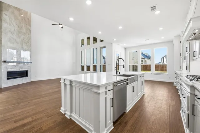 a kitchen with stainless steel appliances granite countertop a stove and a wooden floors