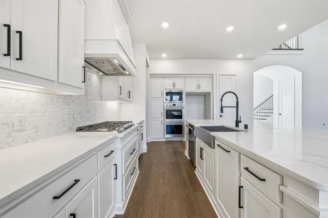 a kitchen with stainless steel appliances a sink stove and cabinets