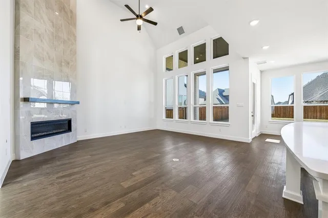 an empty room with wooden floor fireplace and windows