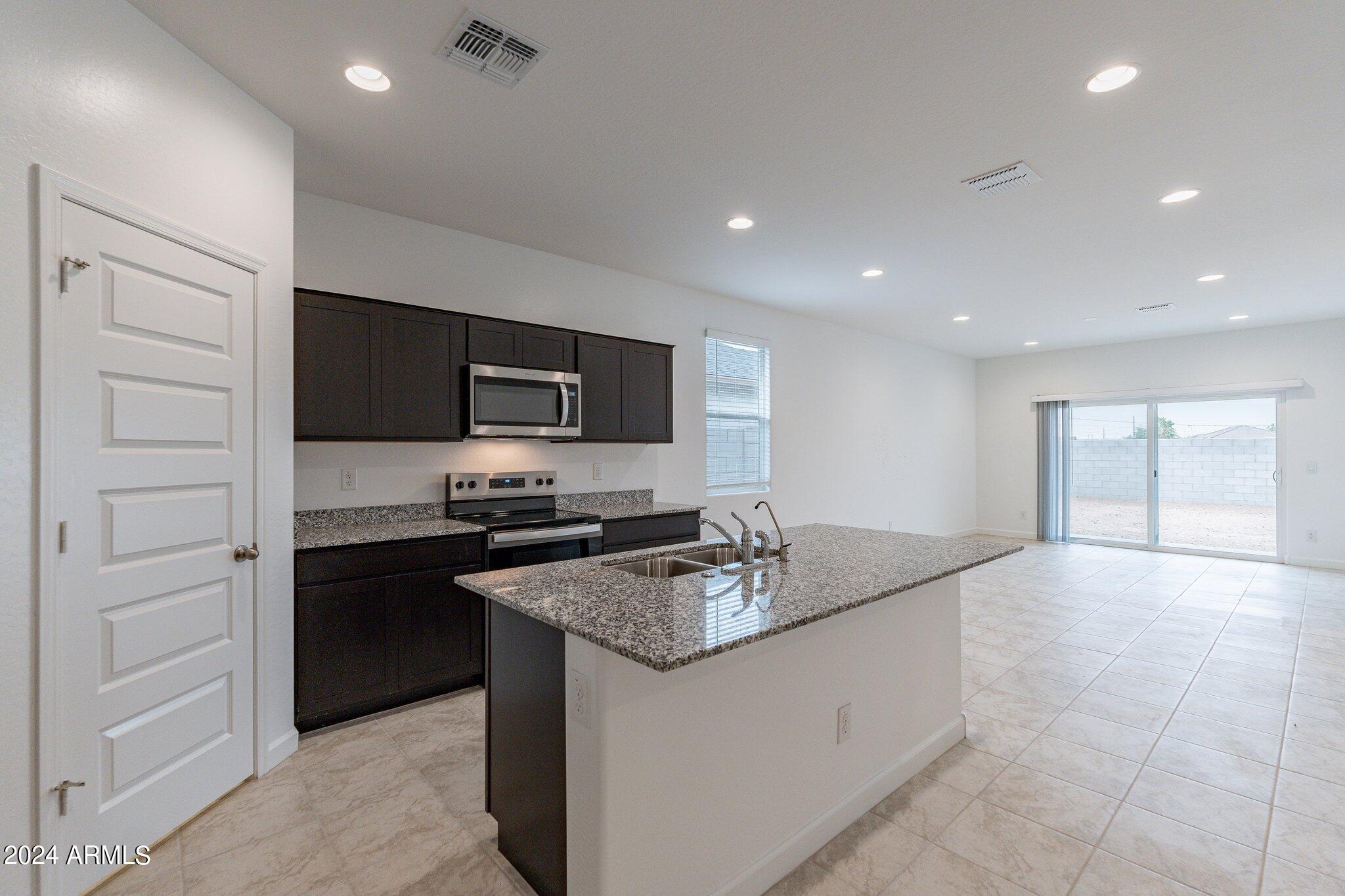 5447 Azara Drive San Tan Valley, AZ 85140 - Photo 4 of 21 a kitchen with a sink and stainless steel appliances