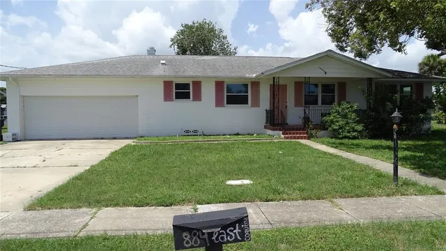 a front view of a house with a garden and yard