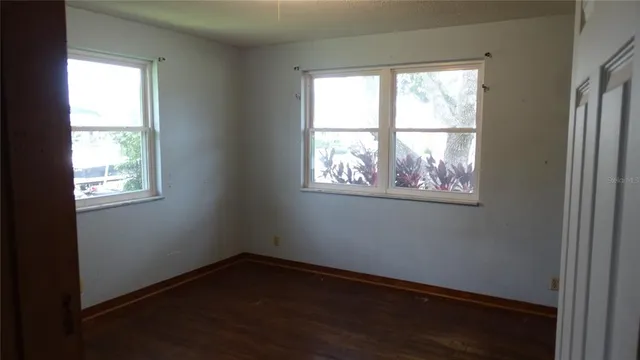 a view of a small space with wooden floor and a window