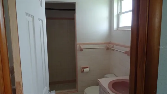a bathroom with a granite countertop toilet a sink and a shower