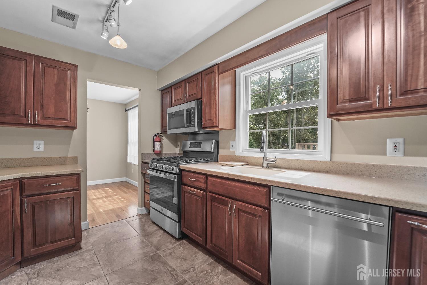 169 Docare Road Jackson, NJ 08527 - Photo 10 of 21 a kitchen with stainless steel appliances granite countertop wooden cabinets a sink and a stove