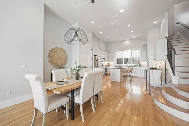 a dining room with wooden floor a chandelier a wooden table and chairs