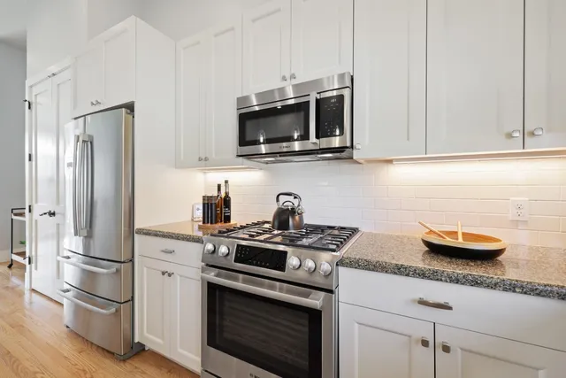 a kitchen with stainless steel appliances granite countertop a stove microwave and refrigerator