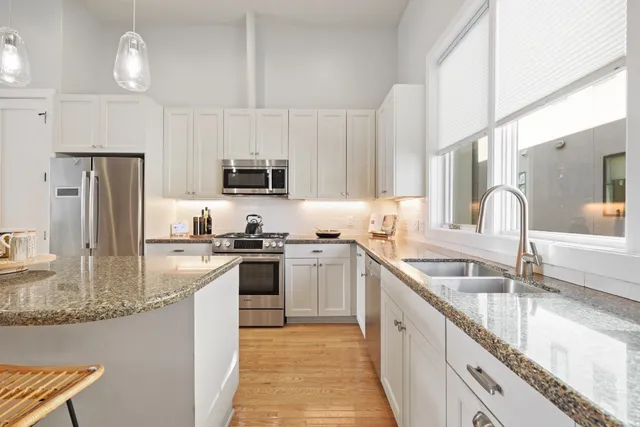 a kitchen with stainless steel appliances granite countertop a sink stove and refrigerator
