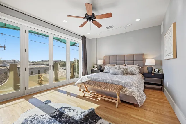 a bedroom with a bed and large glass window with outer view