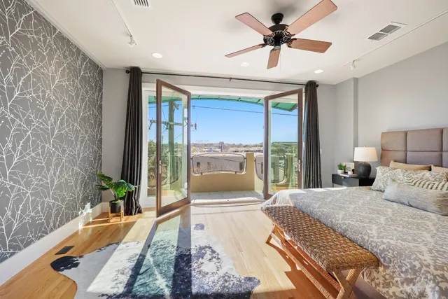 a bedroom with a bed and a large window with balcony view