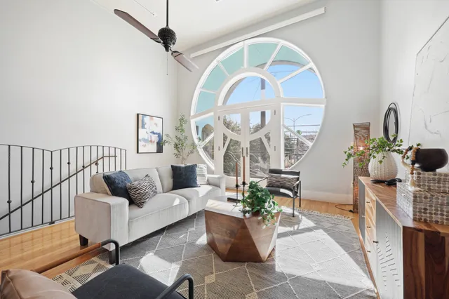 a living room with furniture a potted plant and a chandelier