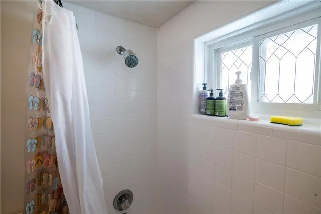 a bedroom with a bed and a flat tv screen on a dresser
