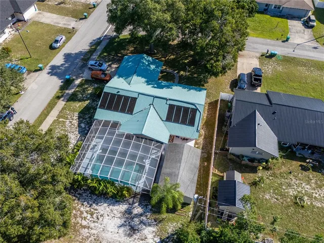 a backyard of a house with table and chairs under an umbrella