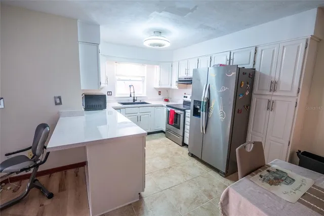 a kitchen with a refrigerator a stove a sink and a dining table