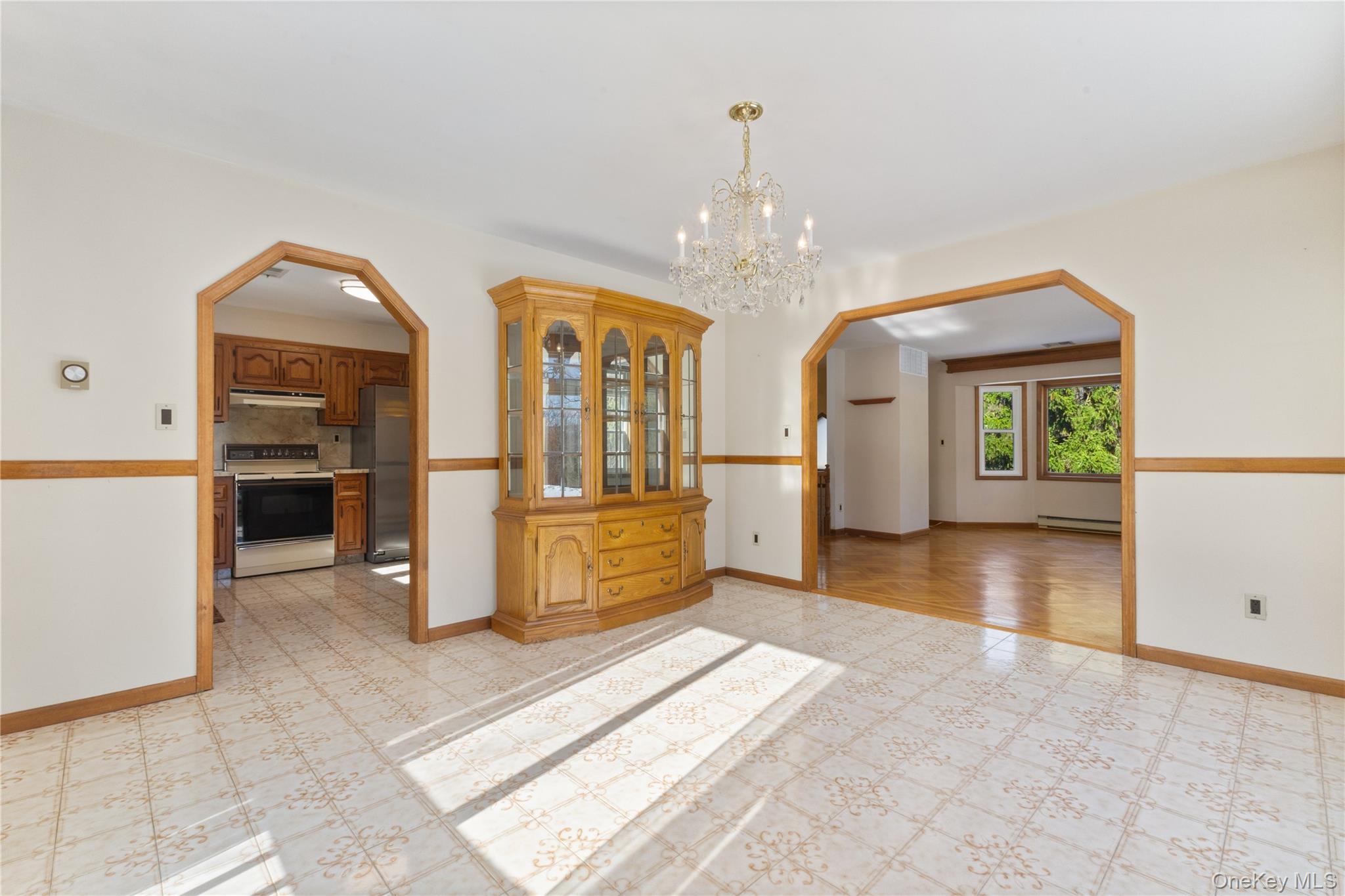 7 Cimarron Road Putnam Valley, NY 10579 - Photo 15 of 50 Spacious dining room with tiled floors and elegant chandelier, perfect for large gatherings.