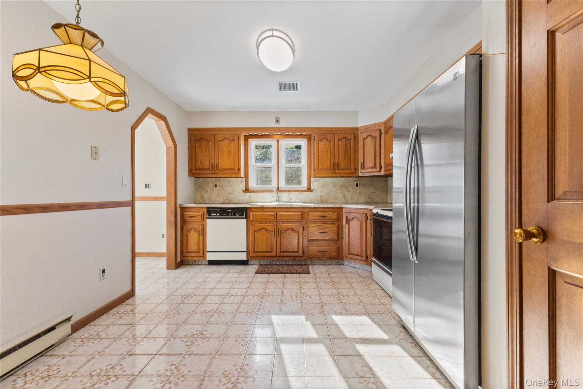 7 Cimarron Road Putnam Valley, NY 10579 - Photo 20 of 50 Spacious eat-in kitchen with a dedicated dining area, classic wood cabinetry, generous counter space, and stainless steel appliances filled with natural light.