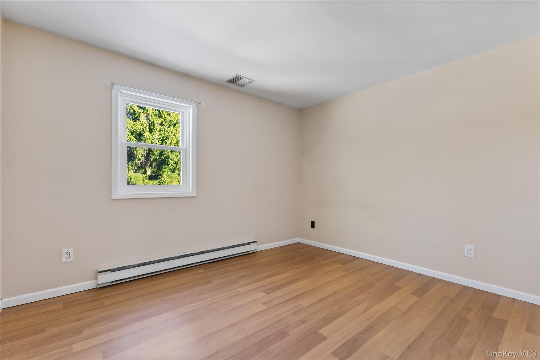 7 Cimarron Road Putnam Valley, NY 10579 - Photo 25 of 50 Cozy bedroom with laminate floors, neutral tones, and a bright window for natural light.