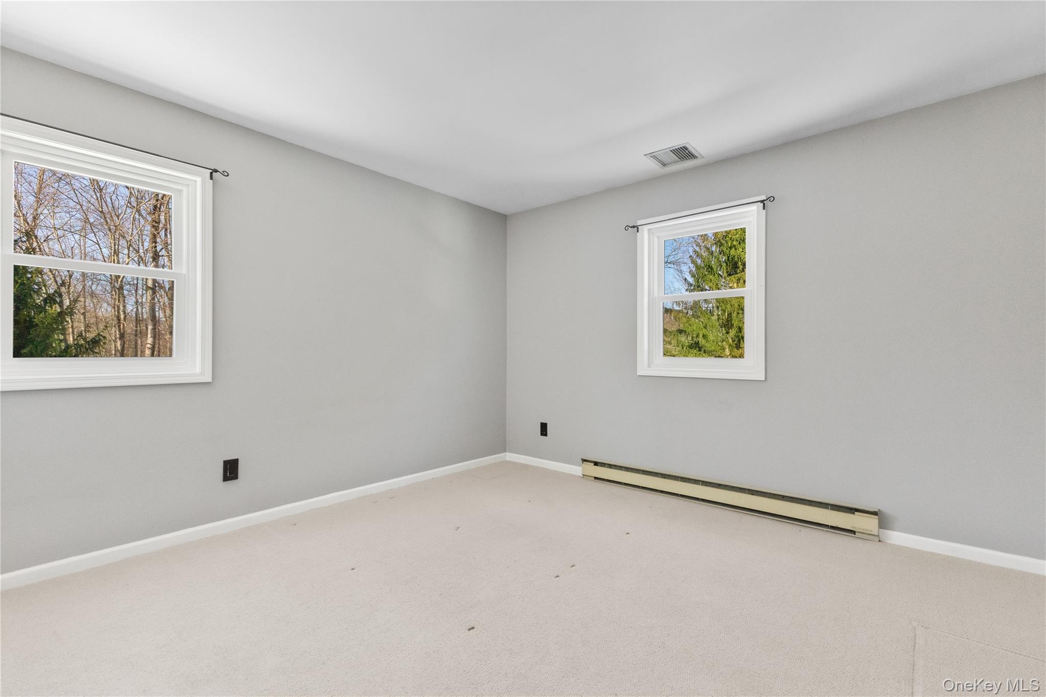 7 Cimarron Road Putnam Valley, NY 10579 - Photo 34 of 50 Bright and inviting bedroom with soft neutral tones, carpeting, and two windows that bring in abundant natural light.