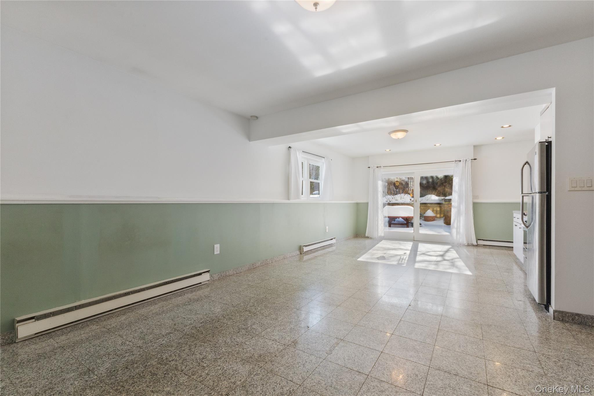 7 Cimarron Road Putnam Valley, NY 10579 - Photo 41 of 50 Spacious lower-level family room with tile flooring, recessed lighting, and sliding glass doors that open to the backyard patio, offering great natural light and indoor-outdoor flow.