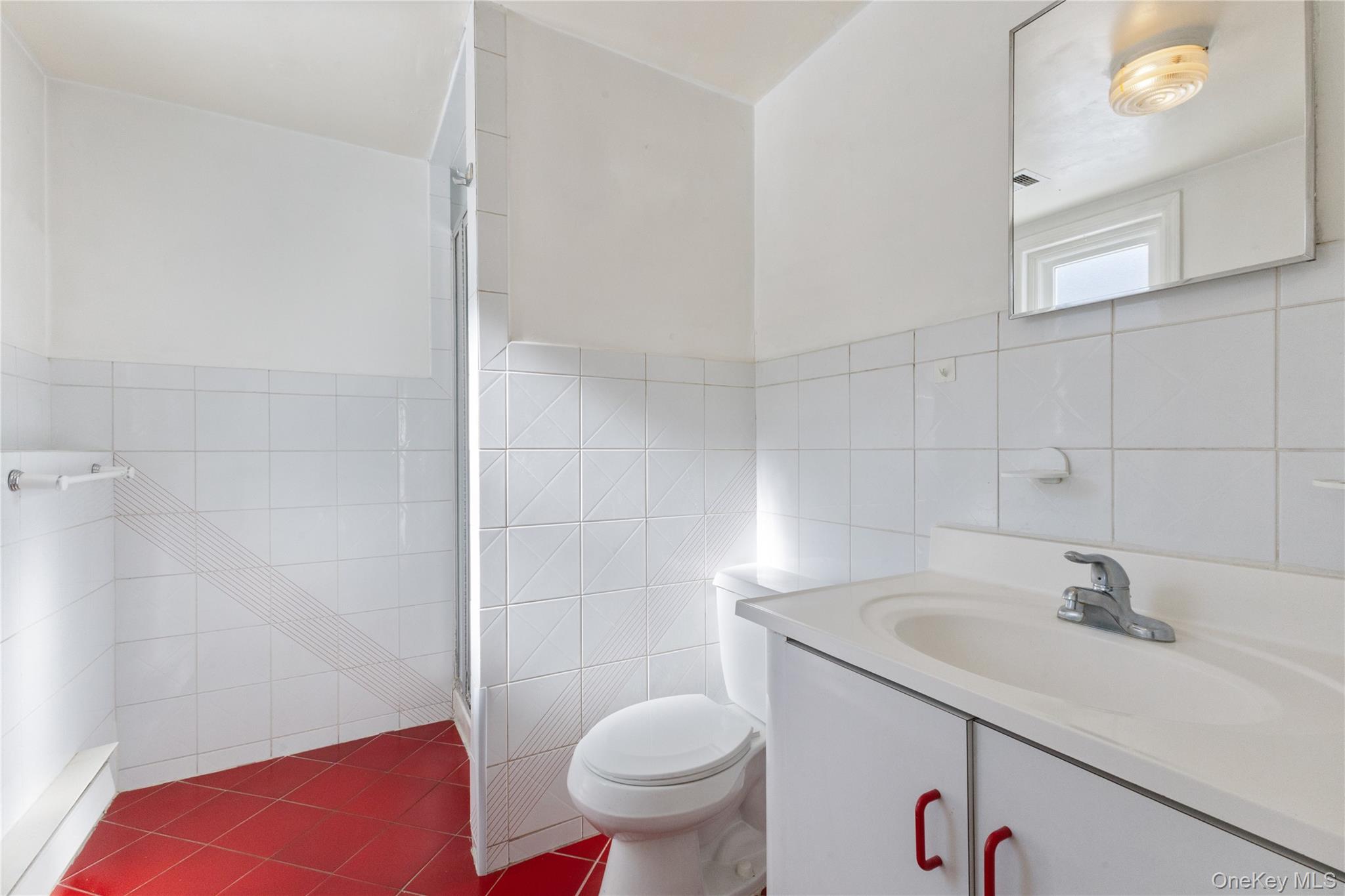 7 Cimarron Road Putnam Valley, NY 10579 - Photo 42 of 50 Lower-level bathroom with walk-in shower, tile finishes, and a convenient single-sink vanity.