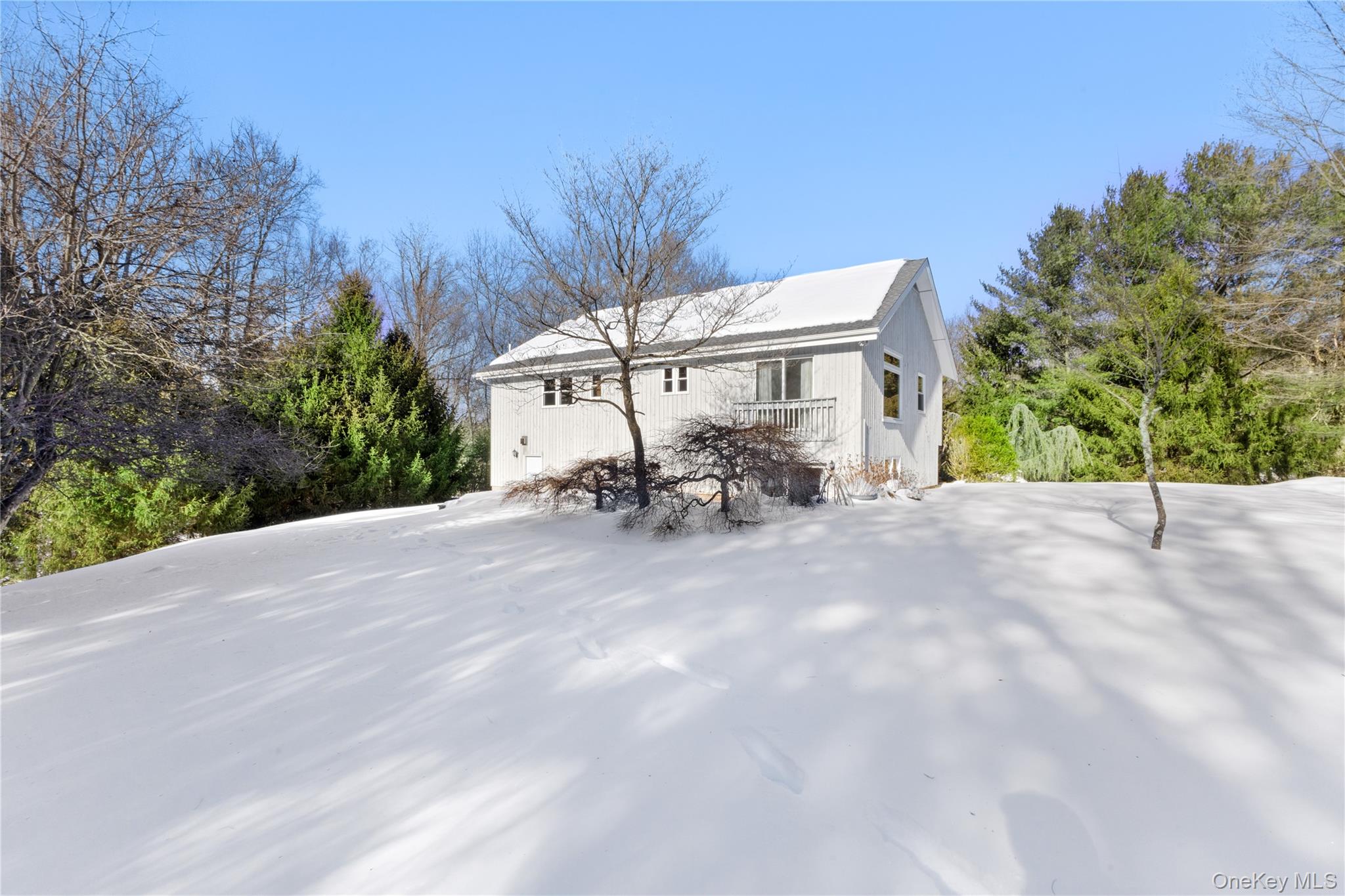 7 Cimarron Road Putnam Valley, NY 10579 - Photo 47 of 50 Beautiful rear exterior showcasing the home’s peaceful setting, surrounded by mature trees and a spacious backyard perfect for year-round enjoyment.