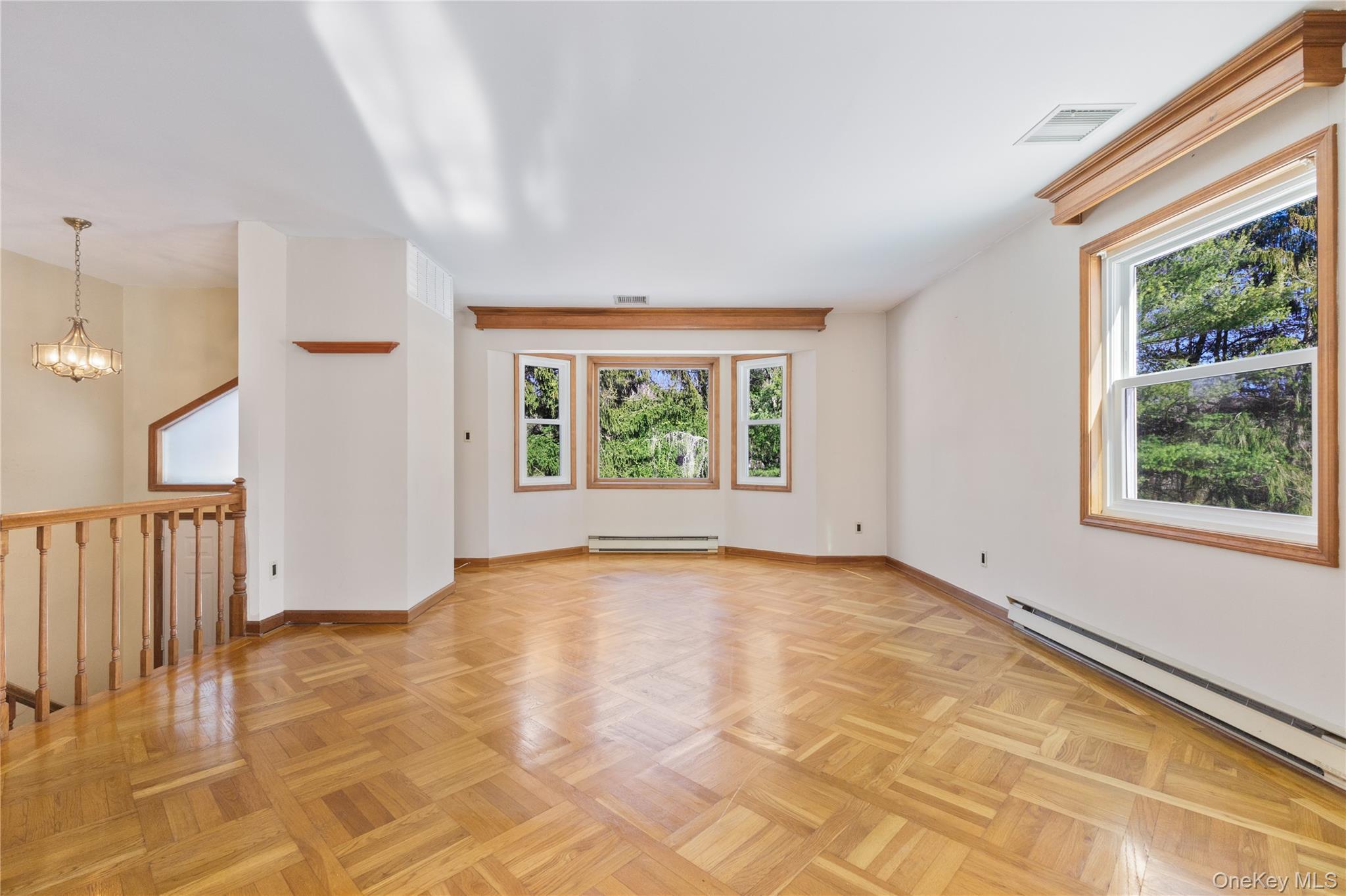 7 Cimarron Road Putnam Valley, NY 10579 - Photo 8 of 50 Spacious living room featuring intricate parquet hardwood flooring and abundant natural light.