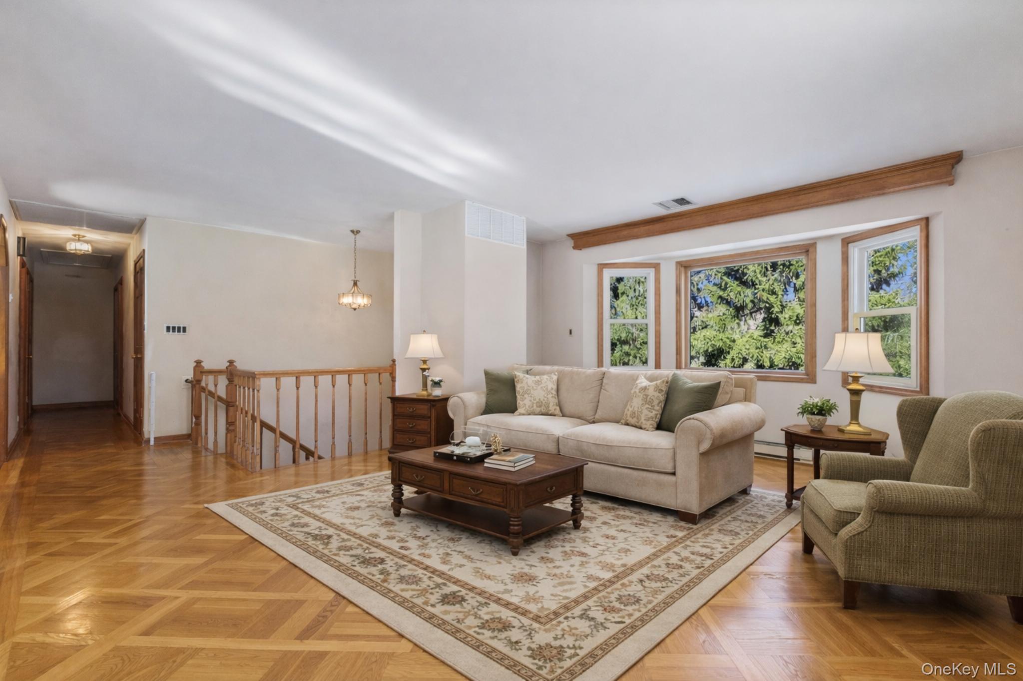 7 Cimarron Road Putnam Valley, NY 10579 - Photo 10 of 50 Virtually staged living room showcasing intricate parquet flooring and bright picture windows.