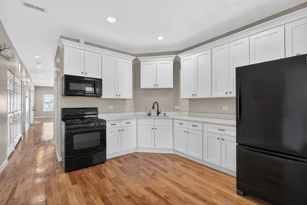 a kitchen with granite countertop white cabinets and stainless steel appliances