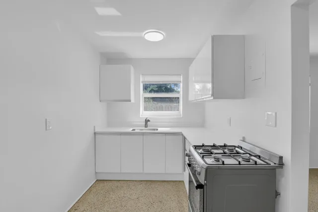 a kitchen with sink stove and window