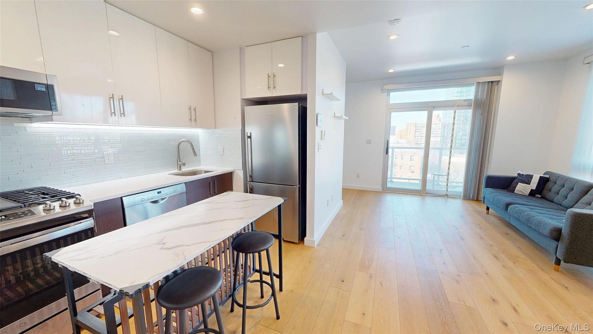 97-29 64th Road Queens, NY 11374 - Photo 1 of 11 a kitchen with stainless steel appliances kitchen island granite countertop a refrigerator a stove a sink dishwasher with a dining table and chairs with wooden floor