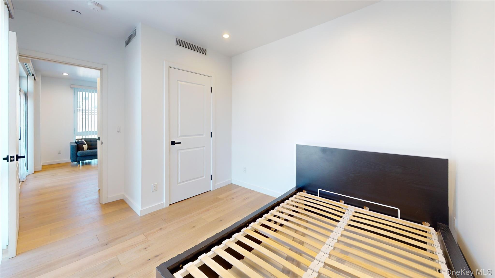 97-29 64th Road Queens, NY 11374 - Photo 8 of 11 a bedroom with a bed and wooden floor